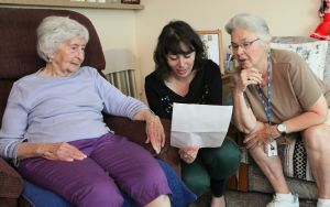 two older women and one younger woman explaining written instructions