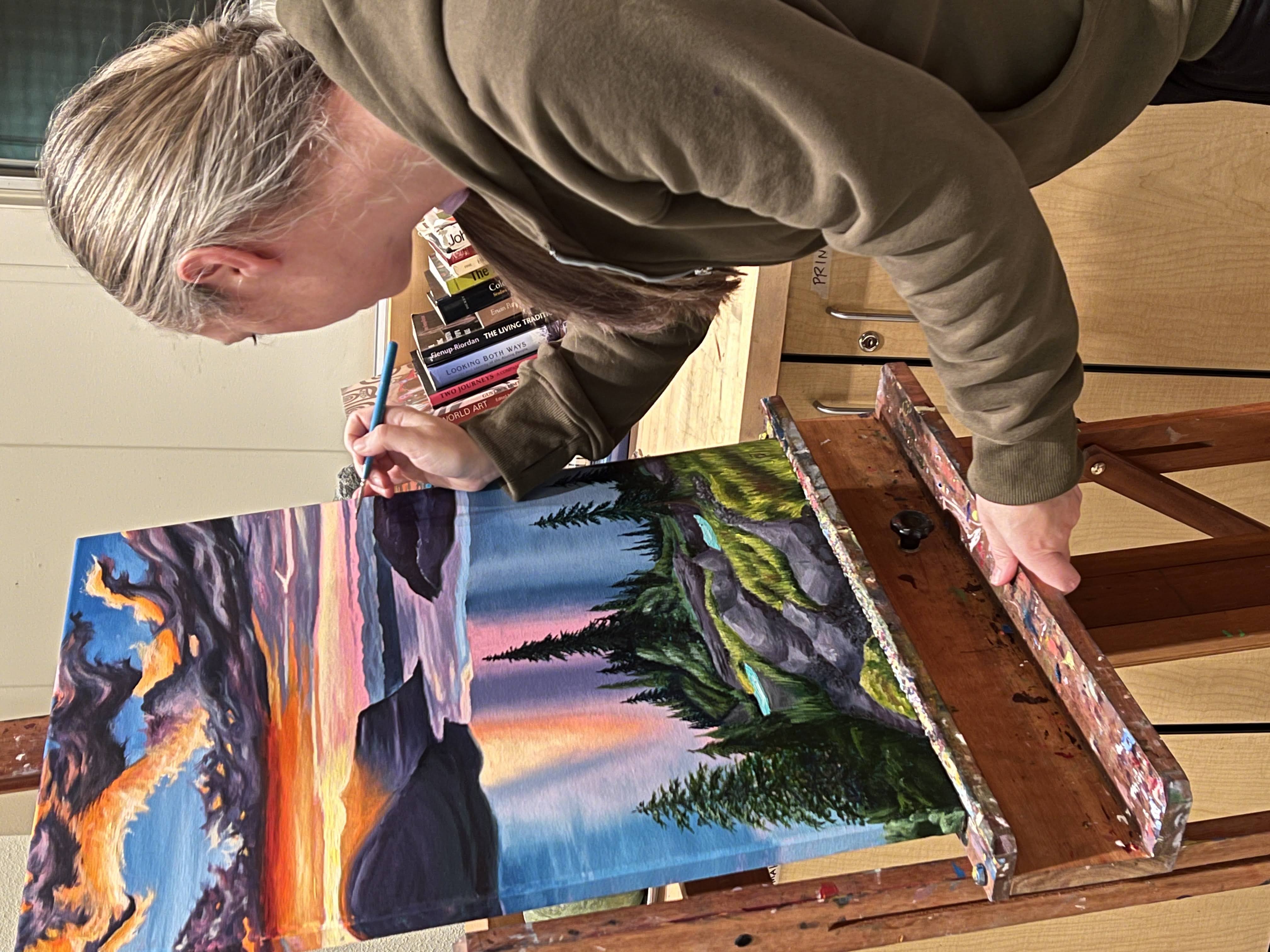 artist painting a brightly colored landscape