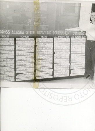 Frank Dunlap beside bowling tournament scoreboard at Sky Bowl alley, Soldotna 1960