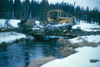 Tractor crossing make shift log bridge during seismograph project, west Cook Inlet early 1960's