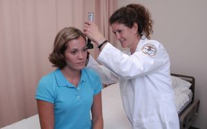 female nursing student looking into female's ear