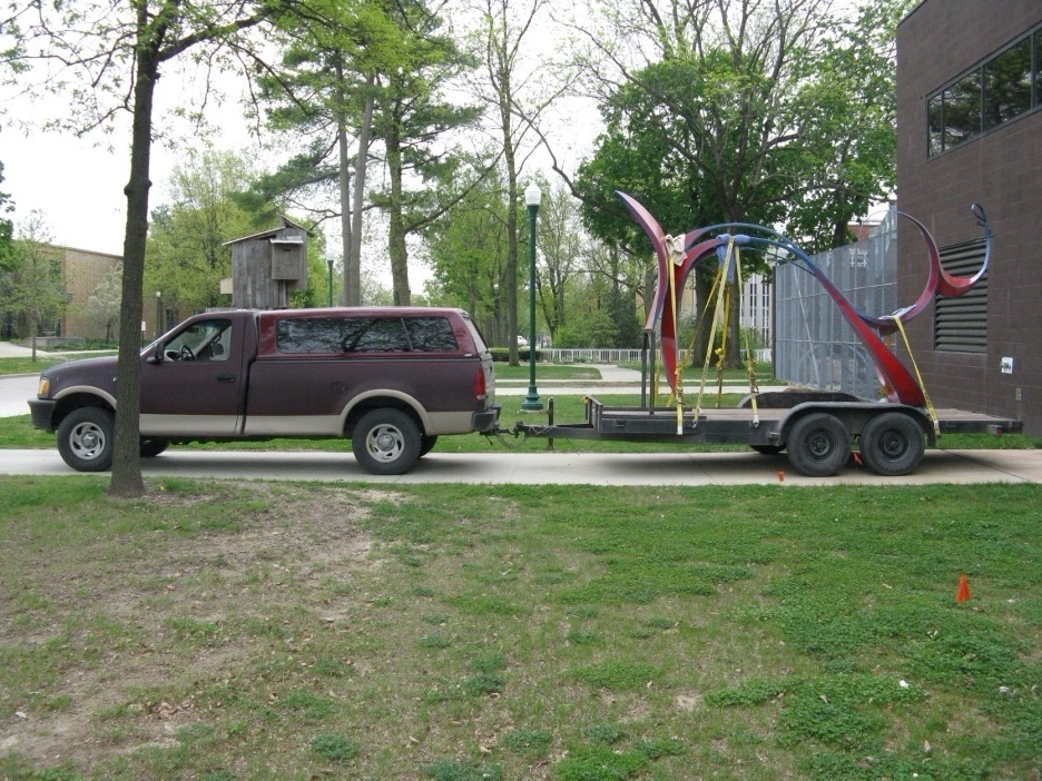 balance sculpture being towed on a trailer